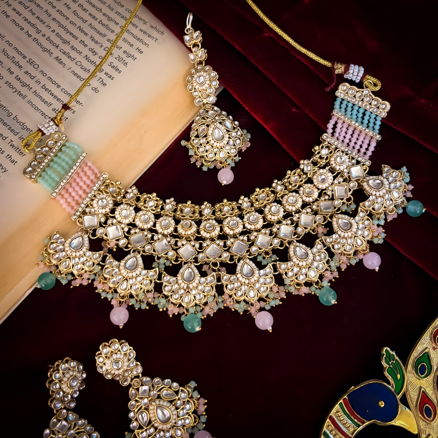 Maisha premium antique gold kundan broad choker necklace set featuring linked tracks of clear dabi stones a dense cascading fringe of pastel pink and mint green quartz beads with matching tiered earrings and maang tikka