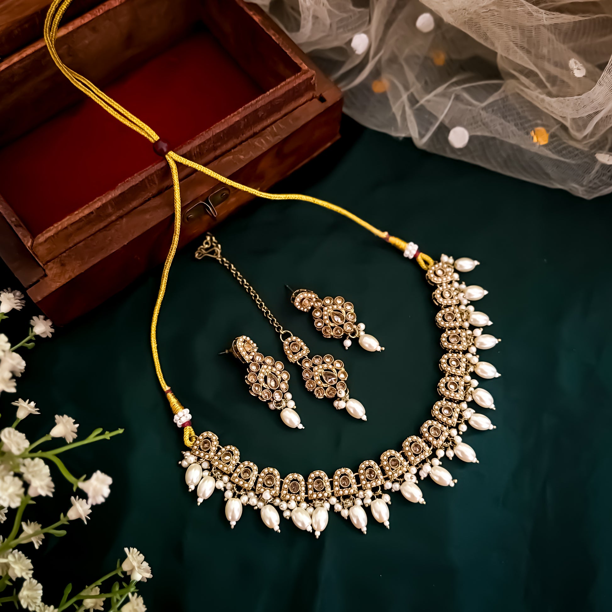 Nitika Jadau Reverse AD Sleek Golden Necklace Set with Earrings & Teeka
