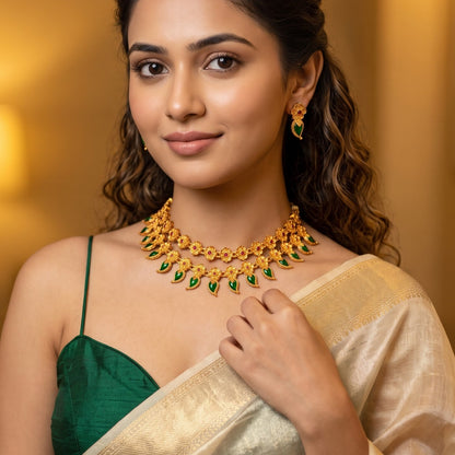 Riva Floral Double Layer premium antique gold temple choker necklace featuring two linked tracks of flower rosettes with pink stone centers and a cascading bottom fringe of emerald green leaf stones alongside matching drop earrings