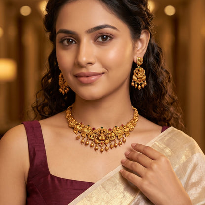 Devika Lakshmi Temple premium antique gold choker necklace set featuring a rigid band with embossed goddess and peacock motifs clear kemp stones and matching dome jhumka earrings