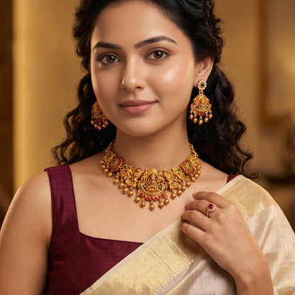 Maheshwari Lakshmi Temple premium antique gold choker necklace set featuring a rigid band with embossed goddess and peacock motifs clear kemp stones and matching dome jhumka earrings