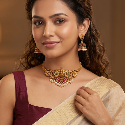 Lekha Peacock Lakshmi Temple premium antique gold choker necklace set featuring a rigid band with embossed goddess and peacock motifs clear kemp stones and matching dome jhumka earrings