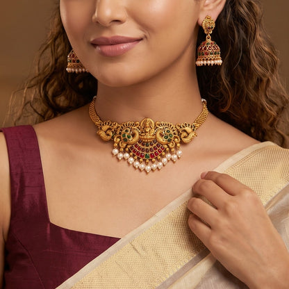 Lekha Peacock Lakshmi Temple premium antique gold choker necklace set featuring a rigid band with embossed goddess and peacock motifs clear kemp stones and matching dome jhumka earrings