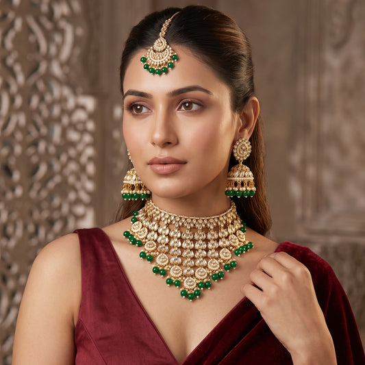 Shameena premium antique gold kundan plunging choker necklace set featuring multi tier tracks of clear dabi stones a dense cascading fringe of white pearls matching dome jhumka earrings and a crescent maang tikka